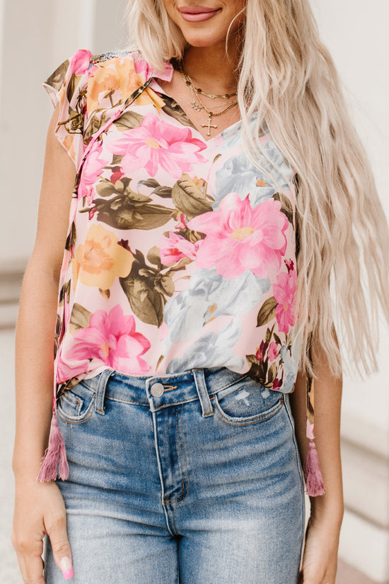 Pink blouse with short sleeves and floral print with pompom and tie