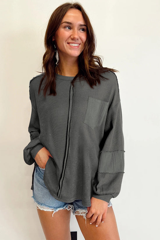 Grey waffle knit top with bubble sleeves and patchwork with exposed seams