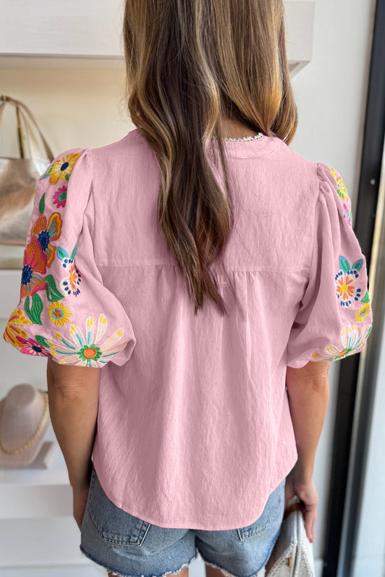 Blusa rosa con cuello dividido y mangas hinchadas bordadas con flores