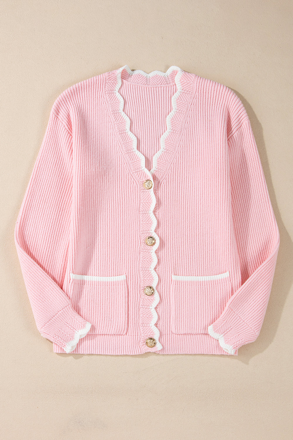 Pink ribbed knit button-up cardigan with side pockets and scalloped edges