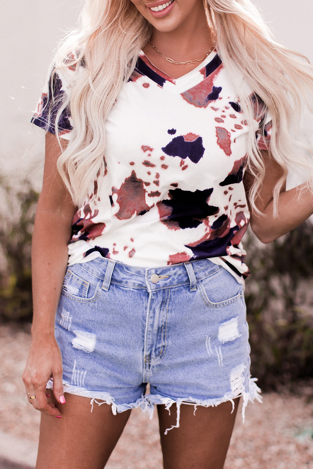 Camiseta blanca con mangas cortas y cuello en V estampado con patrón de vaca