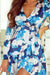 Vestido azul con volante anudado con mangas largas y motivo floral abstracto