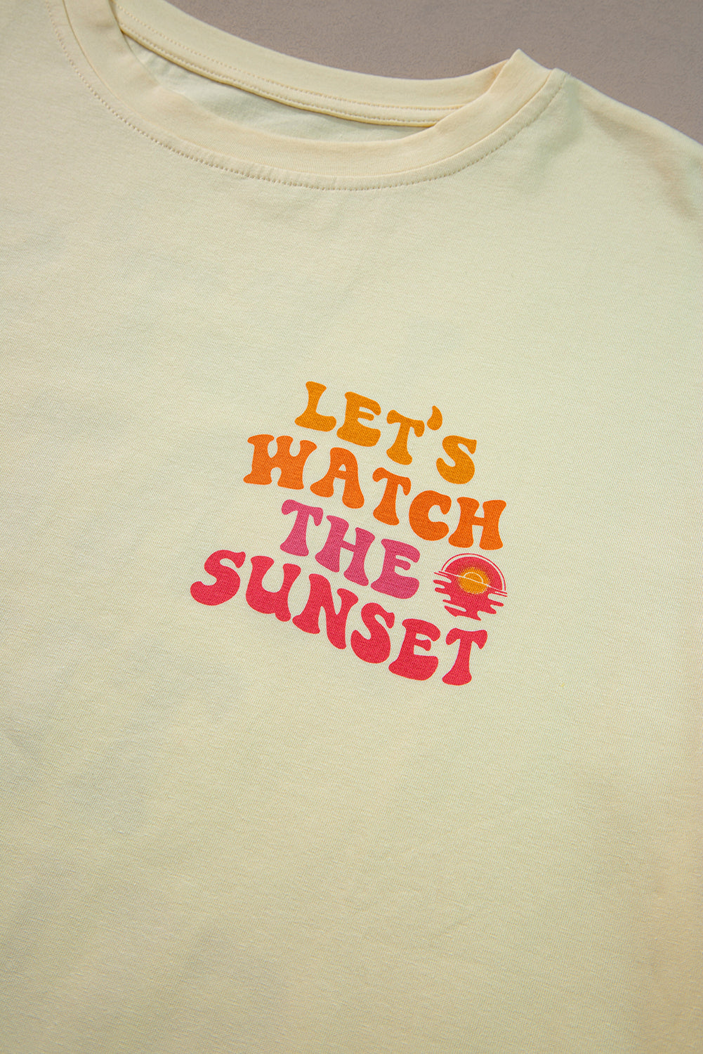 Gelbe Creme Rücken lassen wir uns den Sonnenuntergang mit halben Ärmel -T -Shirt beobachten