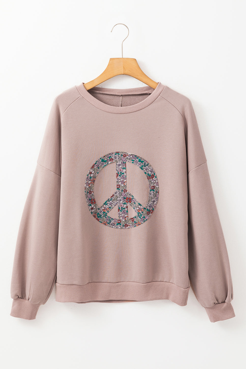 Sudadera de hombro caída y símbolo de paz floral en cabra
