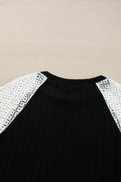 Black ribbed blouse with long sleeves and floral patchwork