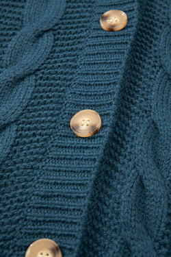 Cardigan baggy bleu paon en tricot torsadé boutonné avec poches sur le devant