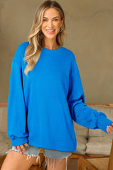 Sudadera básica con manga larga y hombros que caen en un cielo azul liso