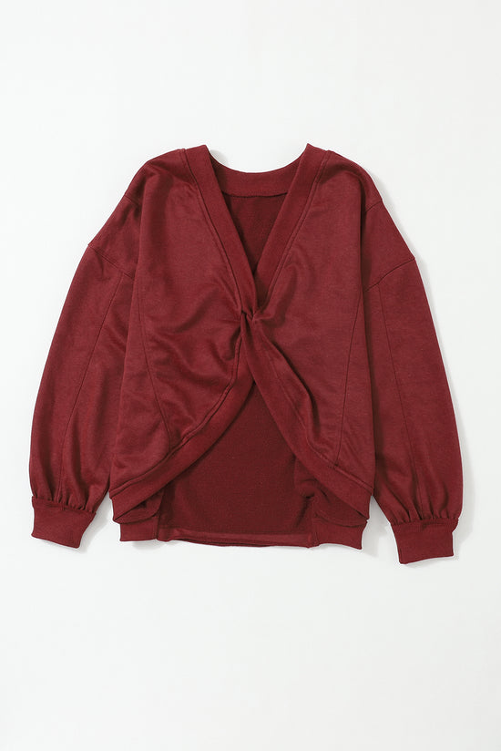 Oversize twisted sweatshirt with open back and bright red exposed seams