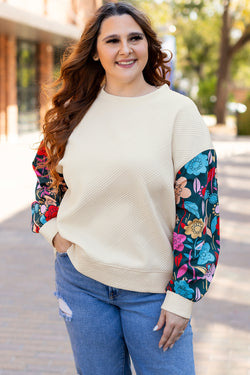 White textured sweater top with patchwork sleeves and large flowers