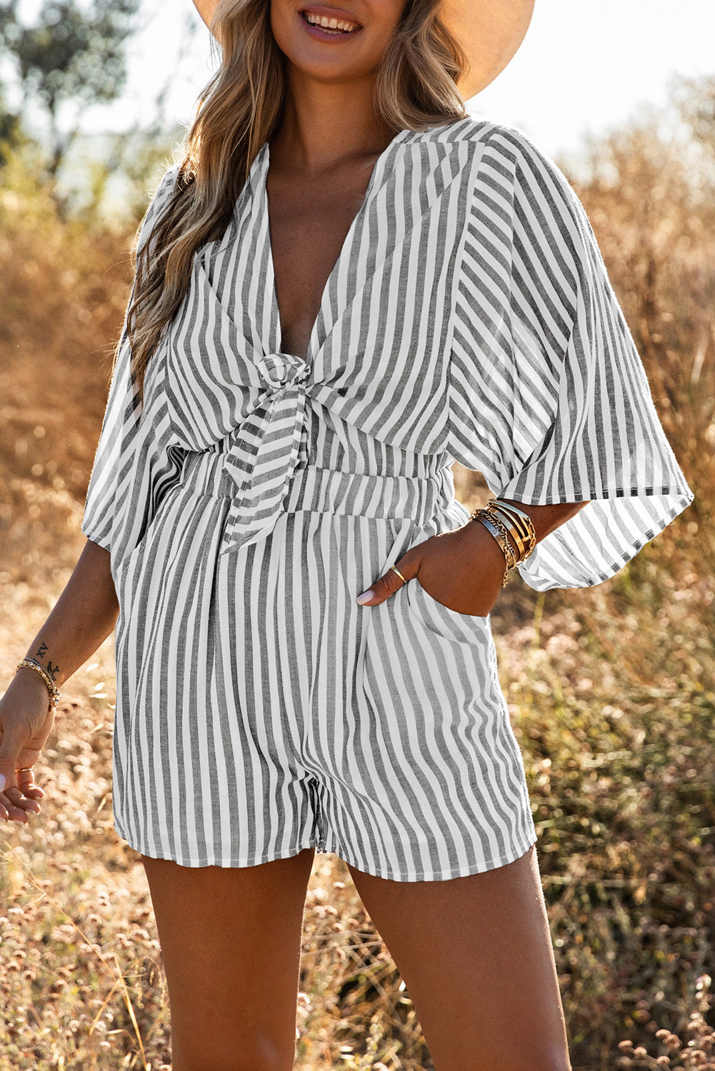 Grey striped romper with 3/4 wide sleeves and knotted front with pockets