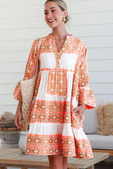 Robe orange à col en V et boutons à volants et imprimé géométrique