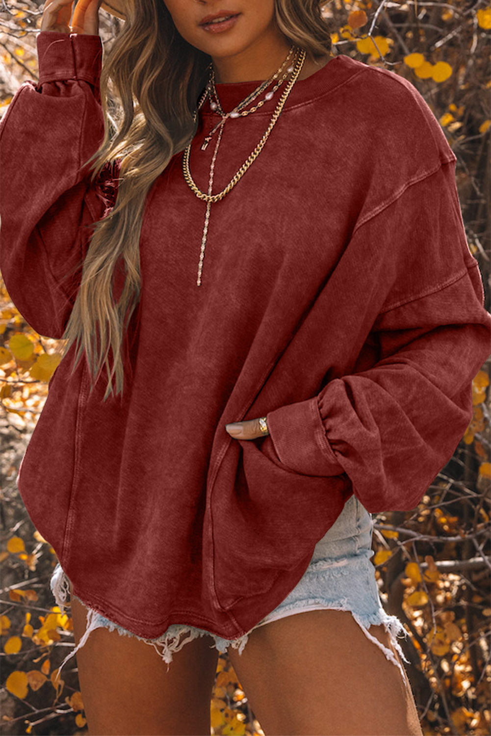 Oversize twisted sweatshirt with open back and bright red exposed seams