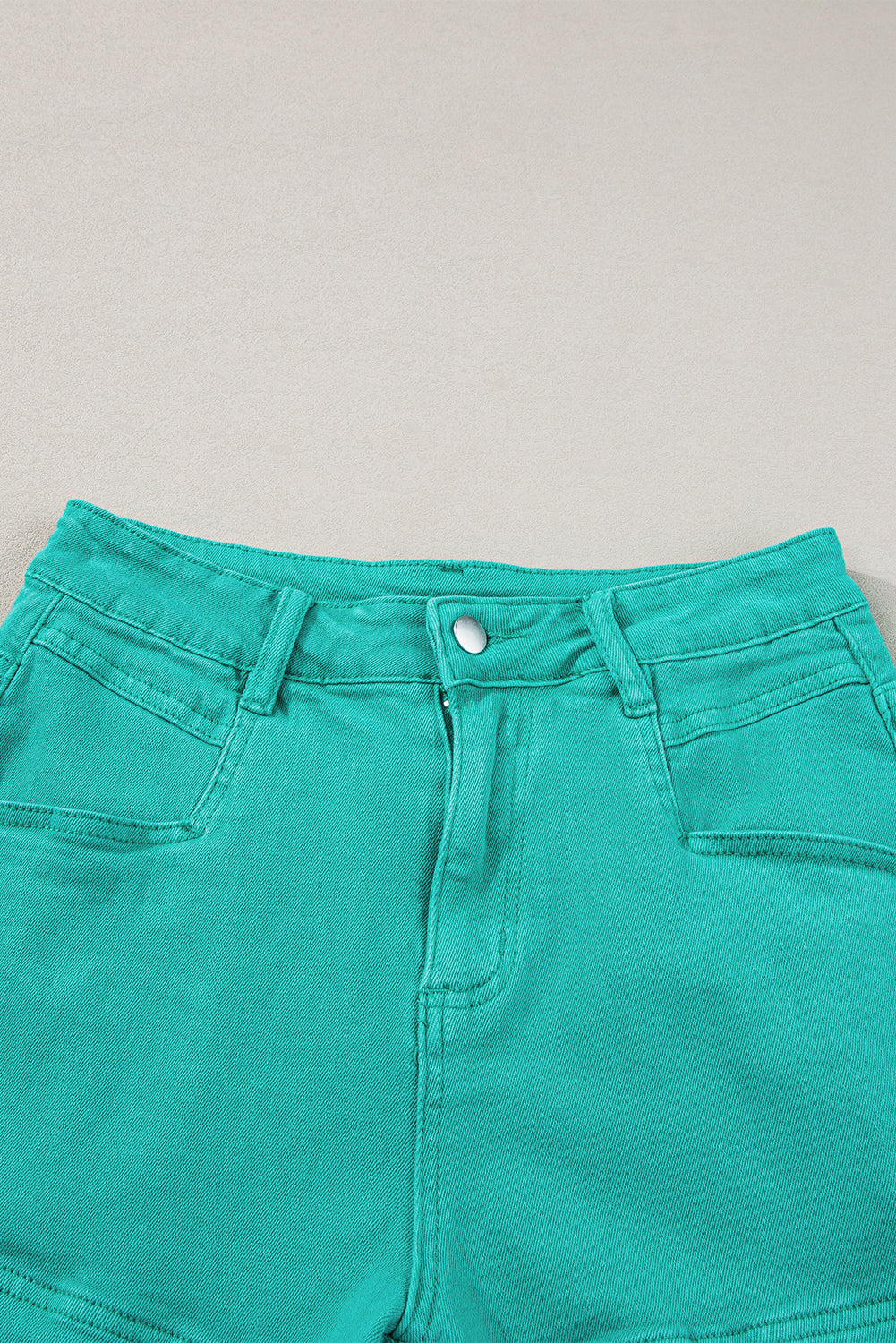 Mid-rise denim shorts with frayed edges in turquoise