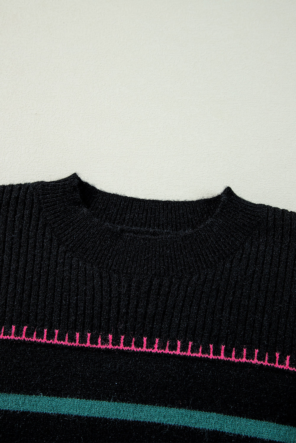 Black sweater with ribbed edges and colorful stripes