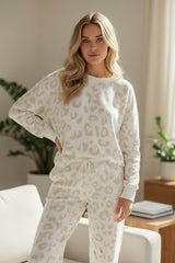 Sala de estar con suéter de leopardo blanco y pantalones de cordón en apriete