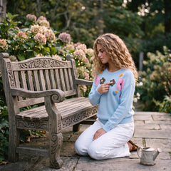 Light blue knitted sweater with ribbed edges and floral pattern