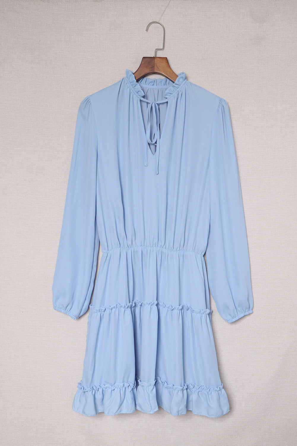 Mini-robe bleu clair à col en V et manches longues à volants et volants