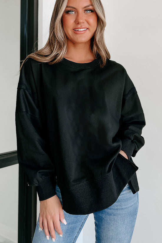 Black sweatshirt with exposed seams, dropped shoulders, round neck, slits