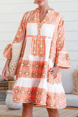 Robe orange à col en V et boutons à volants et imprimé géométrique
