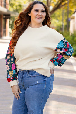 White textured sweater top with patchwork sleeves and large flowers