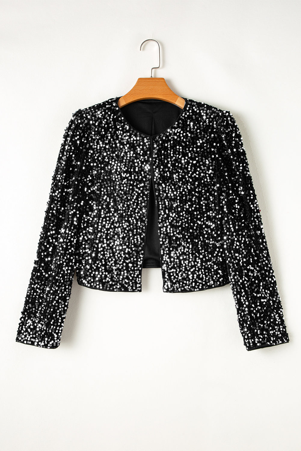 Veste courte noire à sequins ouverte sur le devant