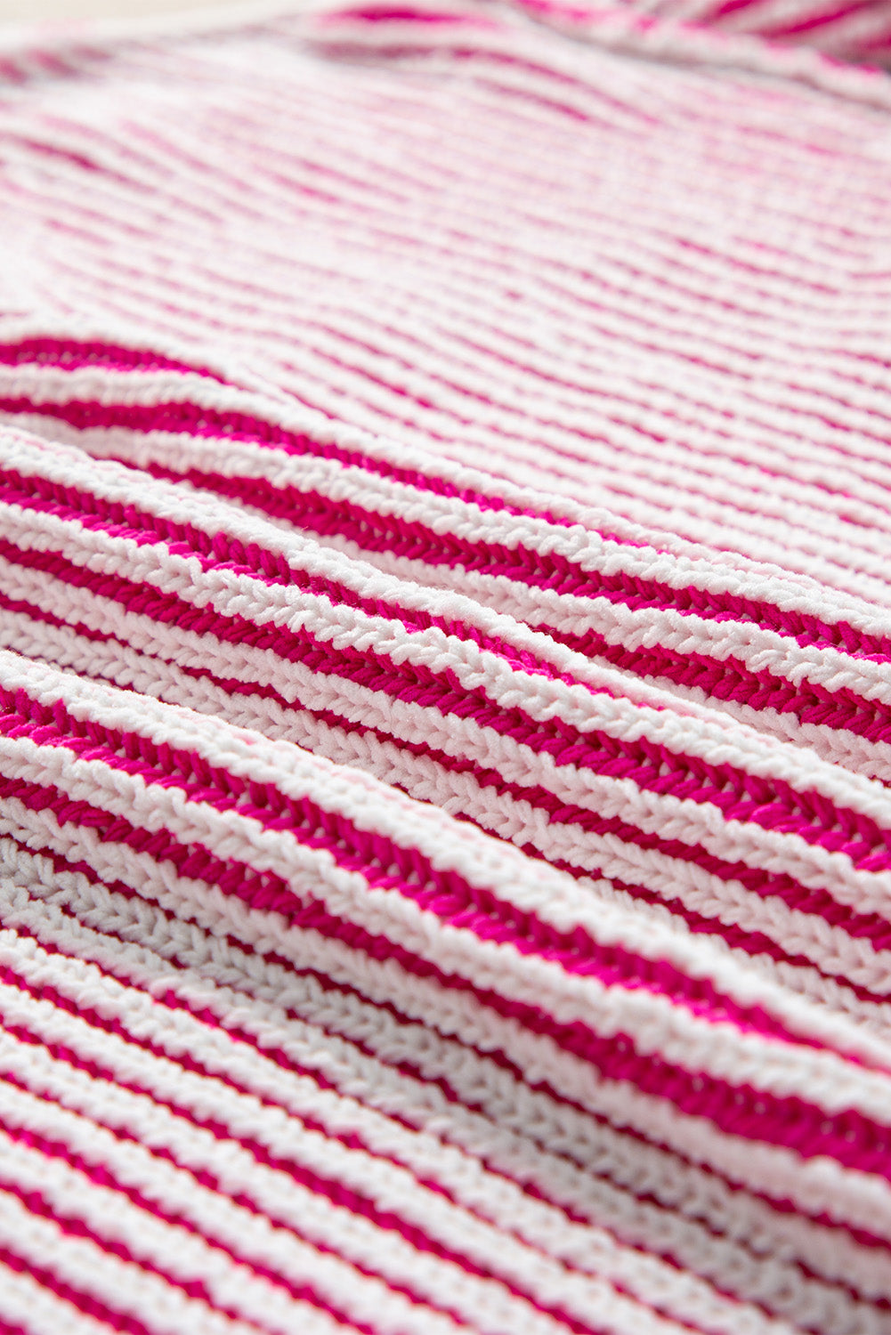 Loose-fitting sweater with contrasting edges in a textured knit with bright pink stripes