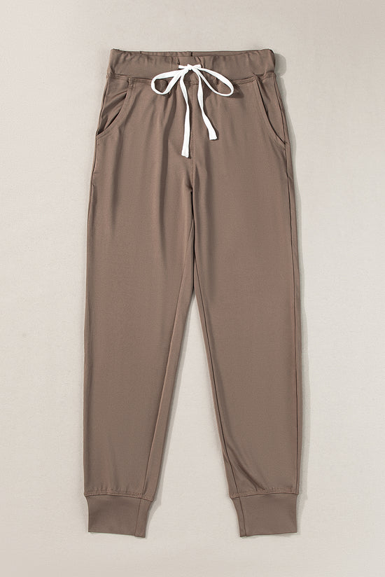 Dark brown jogging pants with pockets and tightening cord at the waist