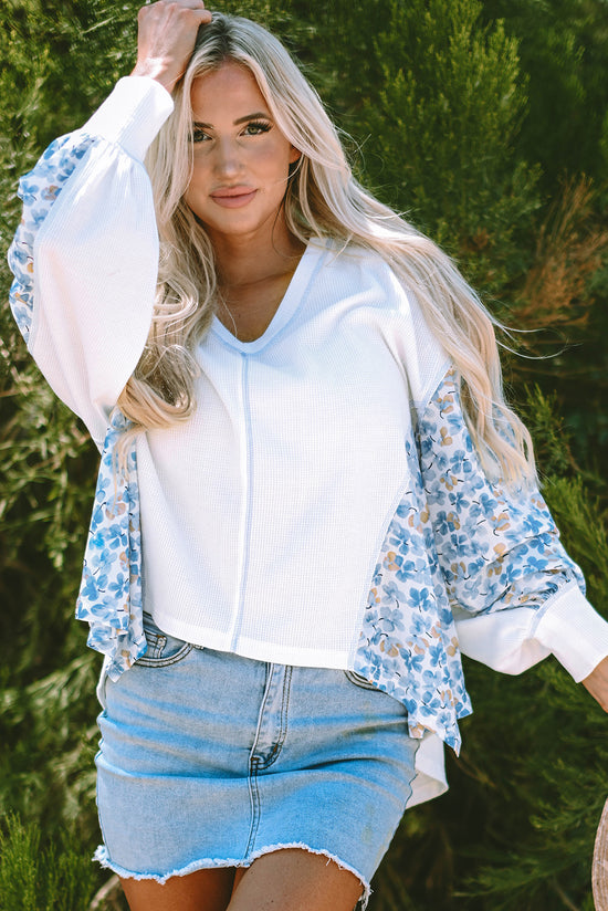 White blouse with bat handles and V-collar with abstract floral pattern