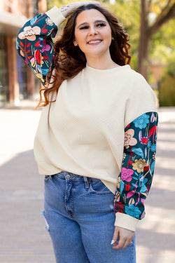 White textured sweater top with patchwork sleeves and large flowers