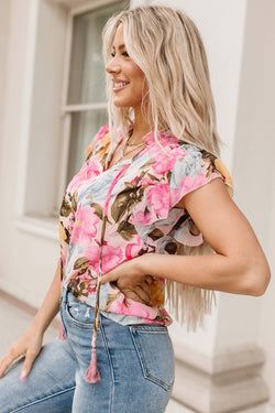 Pink blouse with short sleeves and floral print with pompom and tie