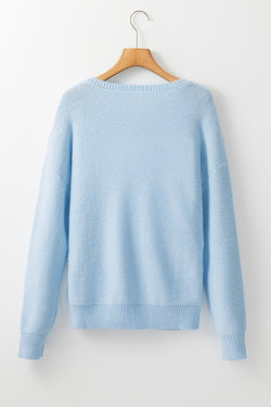 Light blue knitted sweater with ribbed edges with flowers pattern