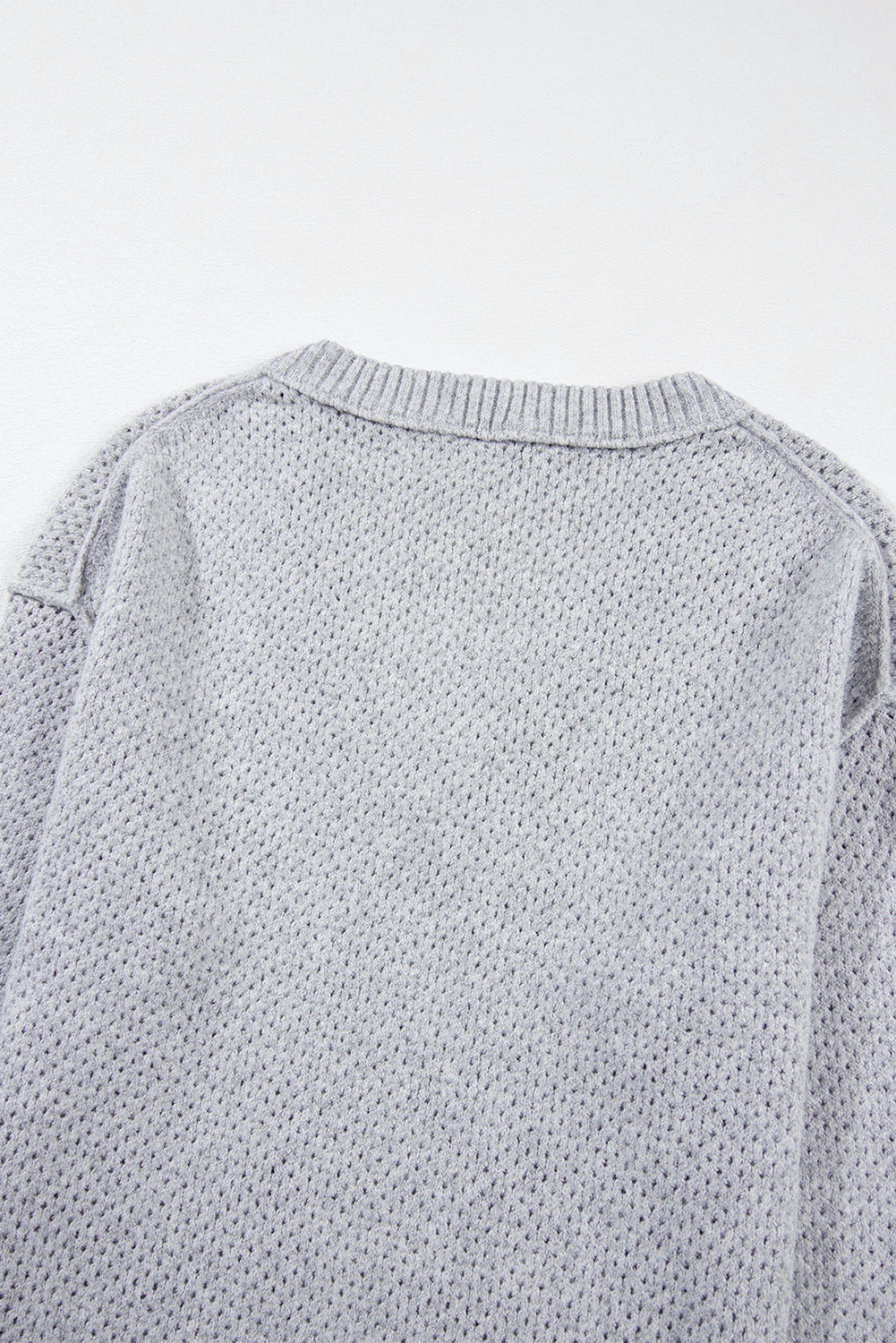 Pull ample gris clair à col en V et épaules tombantes avec œillets