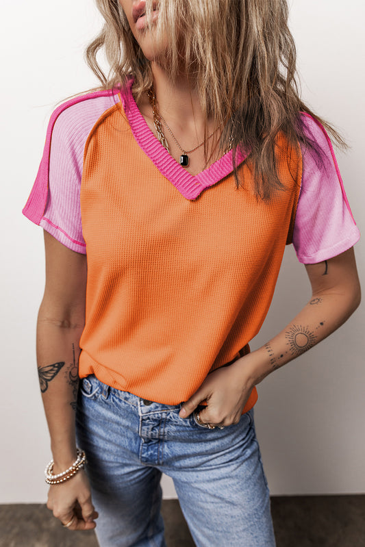 Bloque de color de costura de color naranja Camiseta de cuello en V tejido