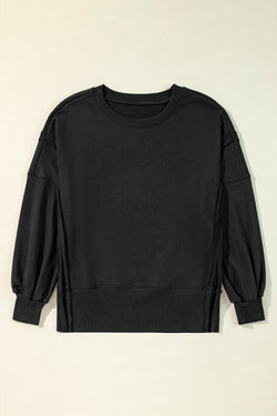 Black sweatshirt with exposed seams, dropped shoulders, round neck, slits