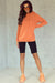 Orange hooded sweatshirt with tightening cord and kangaroo pocket with mineral washing