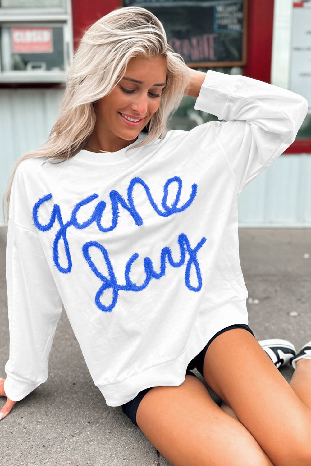 Tinsel Game Day Graphics White Sweins con hombros caídos