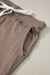 Dark brown jogging pants with pockets and tightening cord at the waist