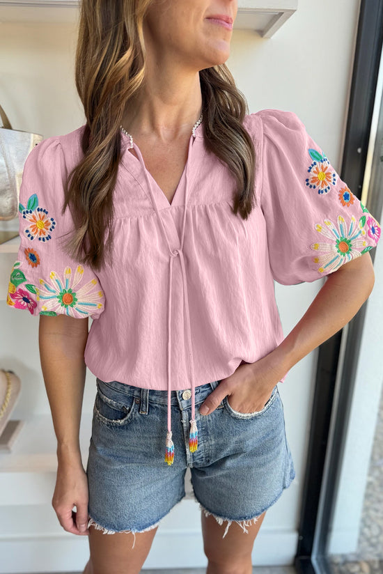 Blusa rosa con cuello dividido y mangas hinchadas bordadas con flores