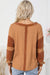 Waffle knit henley top with exposed seams and orange contrast patches