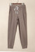 Dark brown jogging pants with pockets and tightening cord at the waist