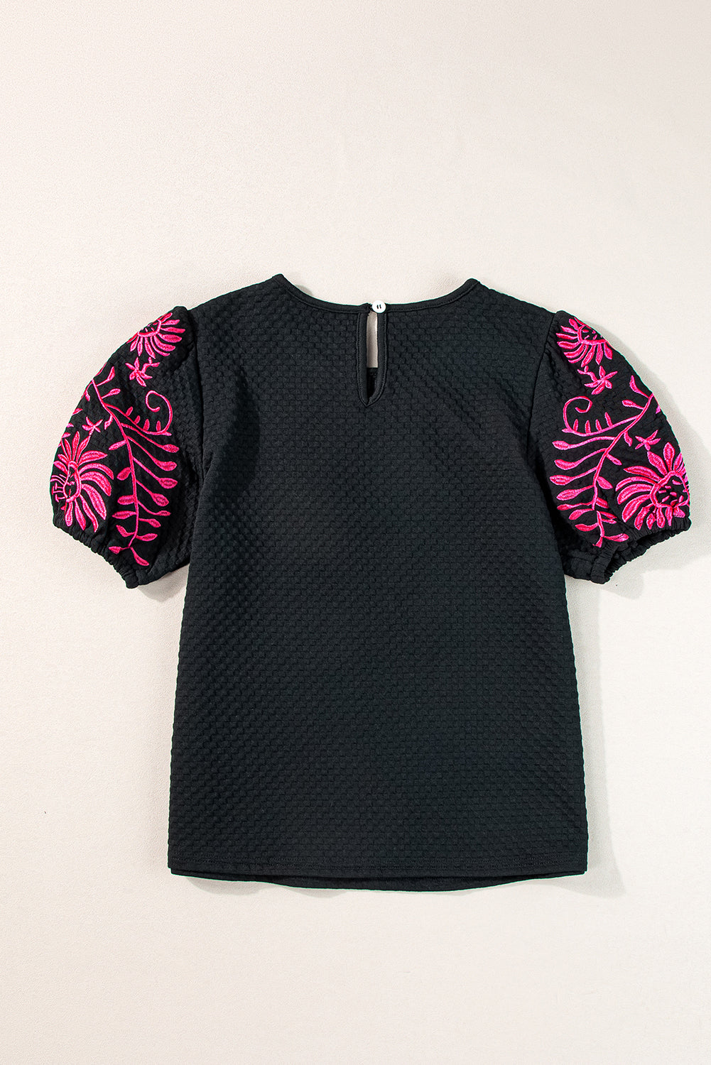 Black t-shirt with puffy textured sleeves embroidered with flowers
