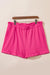 Large pink textured shorts with rolled edges and ruffles, elastic waist