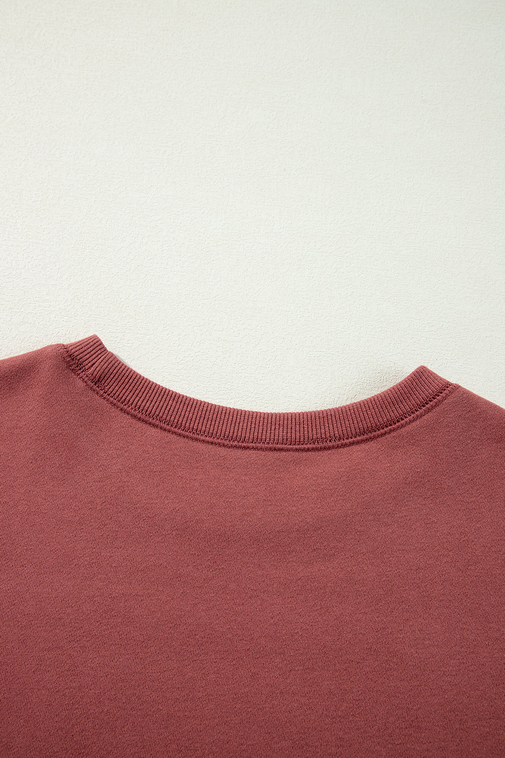 Sudadera de hombro caída en un mosaico rojo mineral