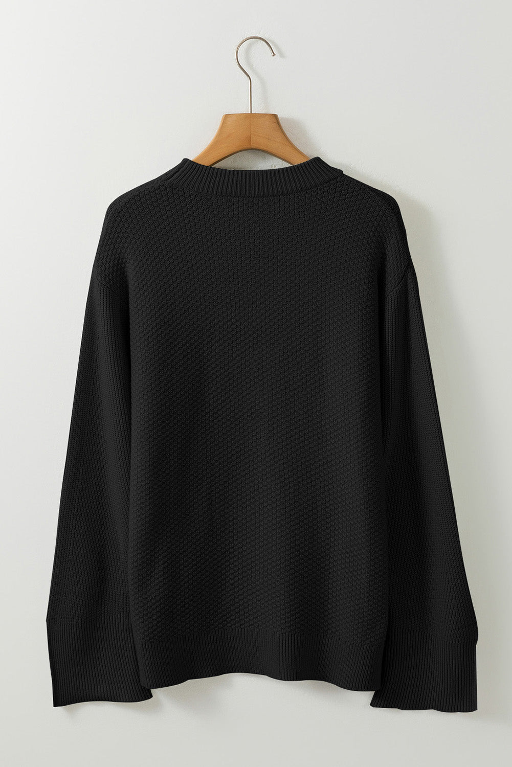 Pull ample noir en tricot texturé uni, manchette fendue, épaules tombantes