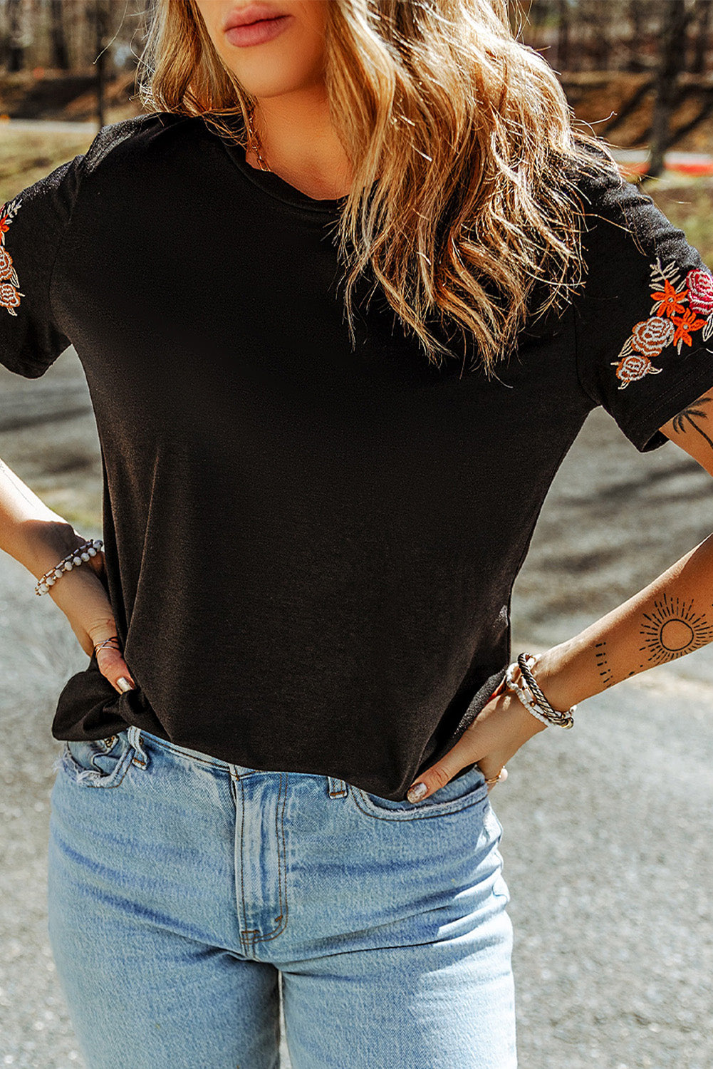 Camiseta negra con mangas cortas y cuello redondo bordado con flores