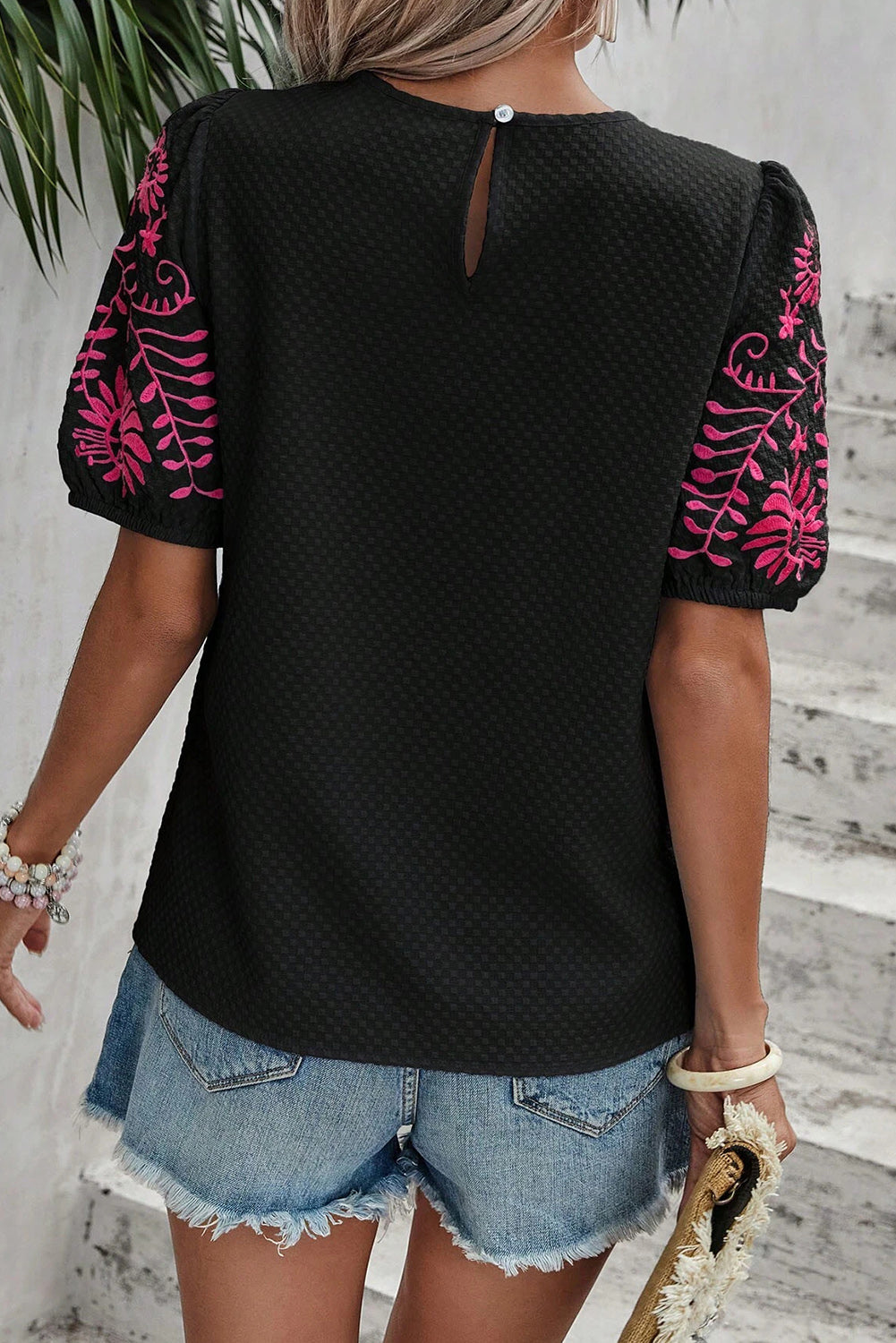 Black t-shirt with puffy textured sleeves embroidered with flowers