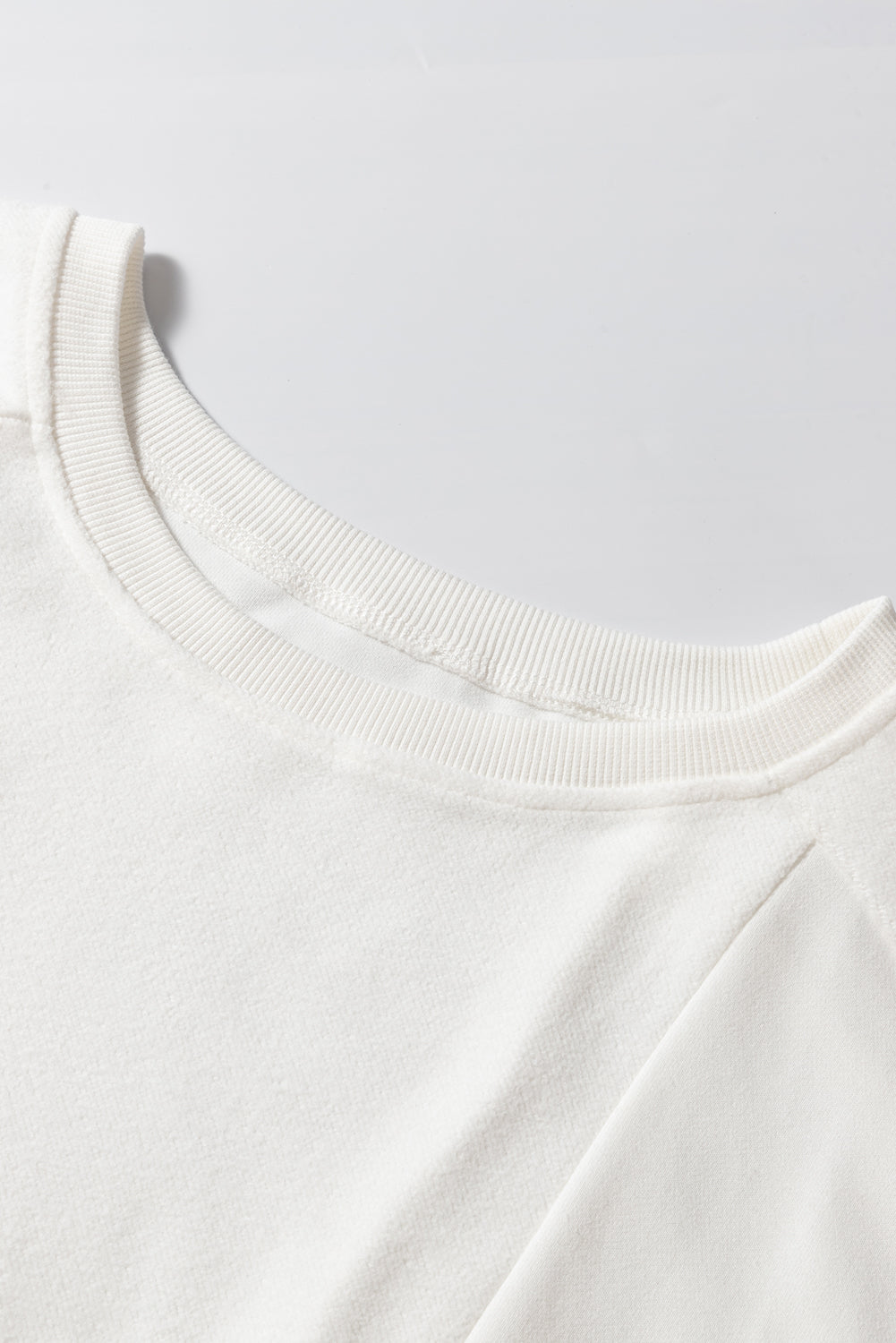 Sudadera holgada blanca con hombro caído y mosaicos lisos