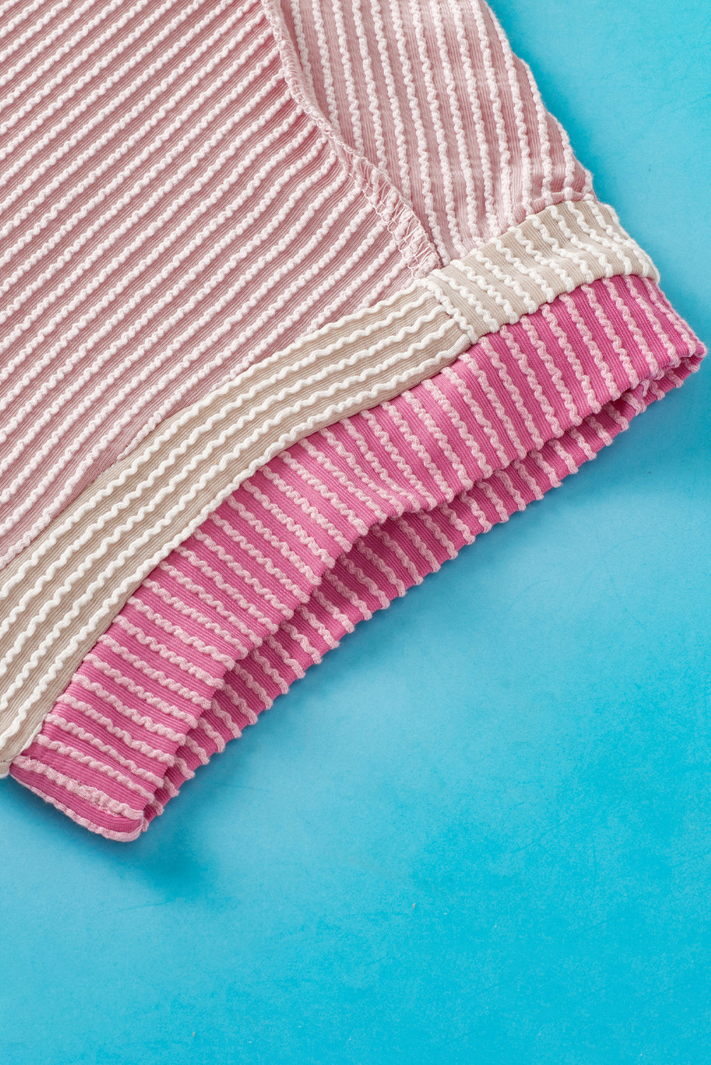 Light pink t-shirt with round neck and contrasting textured border