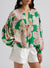 Large folded shirt with puffy sleeves and green floral print button