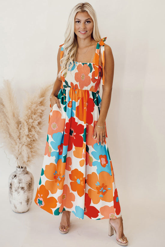 Long orange floral dress with straps tied at the smocked bust